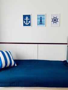 Un dormitorio con una cama azul con cuadros en la pared en Villa Baltic Chałupy Apartament 4 en Chałupy