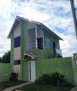 une maison verte avec une porte blanche dans l'établissement Chalés Aconchego, à Cavalcante