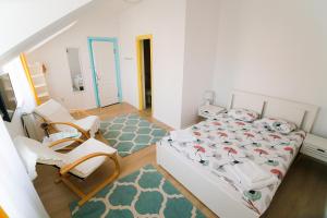 1 dormitorio con 1 cama, 2 sillas y 1 alfombra en Capra Vecinului, en Târgu Mureș