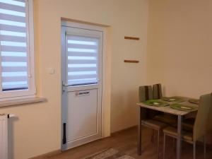 a room with a refrigerator and a table and a window at Cichy Kącik in Kąty Rybackie