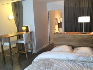 een slaapkamer met een bed, een tafel en een bureau bij Zentral Studio in Gif-sur-Yvette