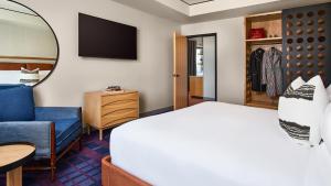 a hotel room with a bed and a television at The Rally Hotel at McGregor Square in Denver
