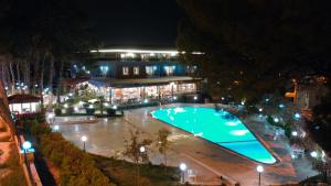 Pamukkale Whiteheaven Suite Hotel في باموكالي: مسبح كبير امام مبنى في الليل