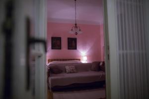 a bedroom with a bed and a pink wall at Kuća za odmor Weinrauch in Ilok