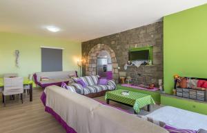 a living room with a couch and a stone wall at Stone House Yiota in Plaka Milou
