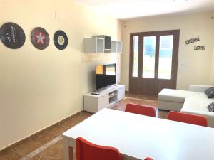 sala de estar con mesa blanca y sillas rojas en Costa Esuri Golf y Playa IV, en Ayamonte