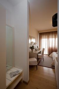 a room with a bed and a desk with a mirror at Hotel Canarie in Lido di Jesolo