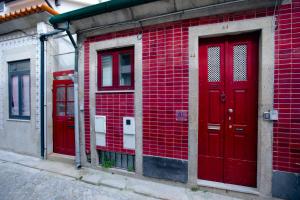 two red doors on the side of a red brick building at Red House- Historic center in Porto