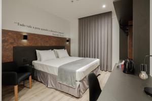 a hotel room with a bed and a chair at Slaviero Chapecó - Pet Friendly - Próximo a EFAPI in Chapecó