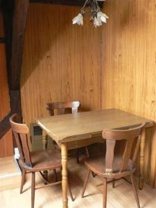 a wooden table with chairs and a wooden wall at Residence 3 Chateaux in Ribeauvillé