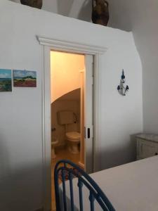a kitchen with a door to a bathroom with a toilet at Casetta delle anfore in Alliste