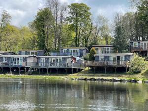 a row of houses on a dock next to a body of water at 92 Lake View in Caernarfon