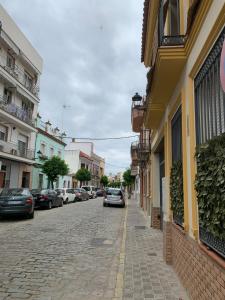 a street with cars parked on the side of a building at Duplex, terraza, 10 min coche centro Sevilla in Camas
