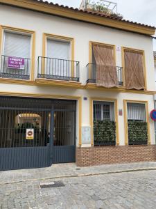 カマスにあるDuplex, terraza, 10 min coche centro Sevillaの黒いガレージのドアと窓のある家