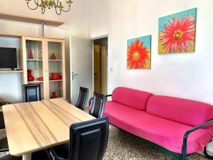 a living room with a pink couch and a table at Meri in Castiglione della Pescaia