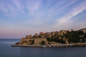 a town on top of a hill in the water at Rooms Molabeciri in Ulcinj