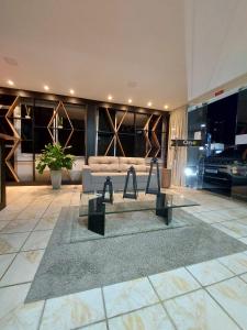 a lobby with a couch and a table in a building at One Hotel in João Pessoa