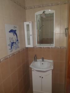 a bathroom with a sink and a mirror at Къща Томови,стаи за гости in Devin