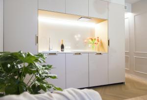 uma cozinha com armários brancos e um vaso de flores em RICCIONE SUITE DESIGN em Riccione