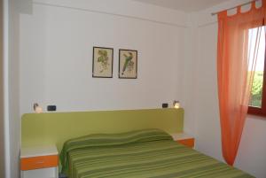 Un dormitorio con una cama verde y una ventana en I Portici Apartments, en Marina di Grosseto