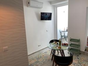 una sala da pranzo con tavolo e sedie in vetro di Casa Térrea 2 Pax Olhão a Olhão