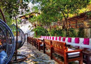 a row of benches with pink and white seats at Pansion Oscar Summer Garden in Mostar