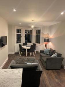 a living room with a couch and a table at The White City Apartment in Oban