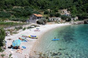 un gruppo di persone sdraiate su una spiaggia in acqua di Apartments Mateo - by the beach; a Gdinj