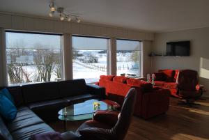 a living room with couches and a table and chairs at Eikeland Gard in Bjerkreim