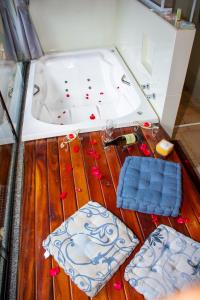 a room with a bath tub and a wooden floor at Pousada Vinhas do Pinhal in Santo Antônio do Pinhal