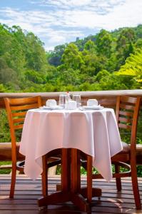 uma mesa com uma toalha de mesa branca num deque em Pousada Vinhas do Pinhal em Santo Antônio do Pinhal