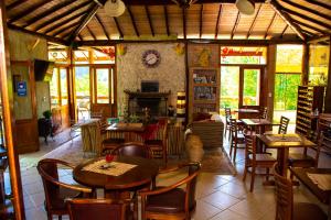 a restaurant with tables and chairs and a fireplace at Pousada Vinhas do Pinhal in Santo Antônio do Pinhal