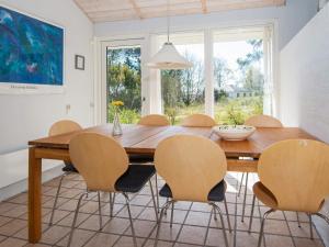 a dining room with a wooden table and chairs at Three-Bedroom Holiday home in Knebel 19 in Knebel
