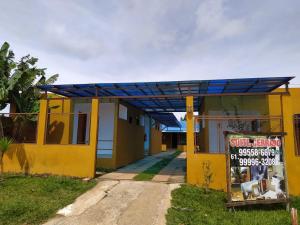 a yellow house with a sign in front of it at Suites Cerrado in Alto Paraíso de Goiás