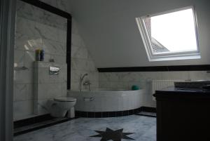 ein Badezimmer mit einer Badewanne, einem WC und einem Waschbecken in der Unterkunft Pension Genengerhof in Viersen