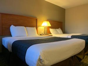 a hotel room with two beds and a lamp at Sunset Inn - John Day in John Day