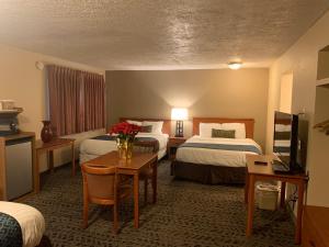 約翰迪的住宿－Sunset Inn - John Day，酒店客房,设有两张床和一张鲜花桌。