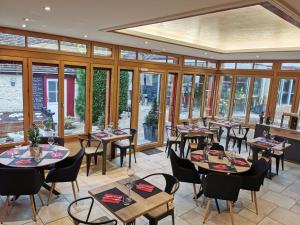 a restaurant with tables and chairs and windows at O'GB La Rennaissance in Chenonceaux