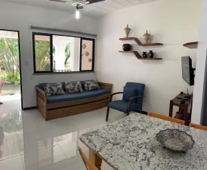 uma sala de estar com um sofá e uma mesa em Guarajuba Summer Flat 10 em Guarajuba