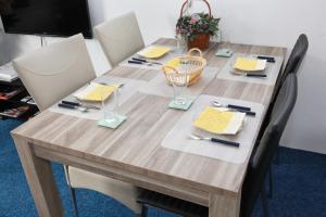 una mesa de madera con sillas alrededor con platos y vasos en Teska Bed & Breakfast en Veenendaal