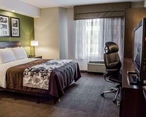 里士滿的住宿－Sleep Inn Richmond North，酒店客房配有一张床、一把椅子和一台电视。