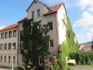 Un edificio con un'edera sul lato. di Pension Mahrets Puppenstube a Eisenach