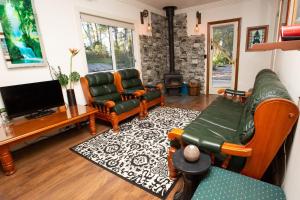 a living room with two couches and a tv at Dorrigo Bush Pepper Retreat in Deer Vale