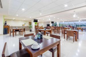 a restaurant with wooden tables and chairs and a cafeteria at Sleep Inn Torreon in Torreón