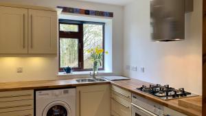 a kitchen with a stove top oven next to a sink at Gallery Cottage in Aberdeen