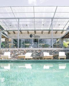 a swimming pool with chairs in front of a building at Altos de la Serena Apart Hotel in La Paloma