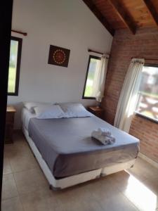 a bedroom with a bed in a room with windows at Atardecer Serrano in Villa General Belgrano