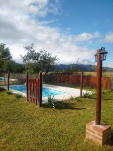 una valla de madera junto a una piscina en Atardecer Serrano en Villa General Belgrano