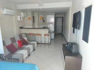 a living room with a couch and a kitchen at loft Prainha in Arraial do Cabo