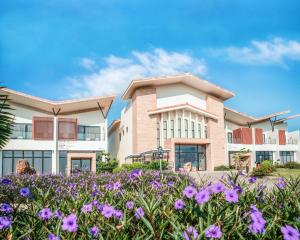 a building with purple flowers in front of it at SkyeBay Club in Hengchun